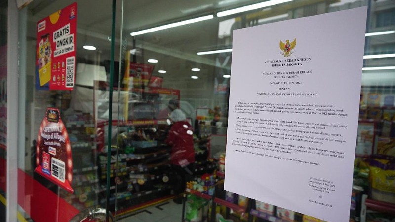 Petugas Satpol PP Jakarta Barat menutup gerai minimarket yang menjual rokok di Alfamart, Jakarta Barat, Selasa (14/9/2021). (CNBC Indonesia/Tri Susilo)