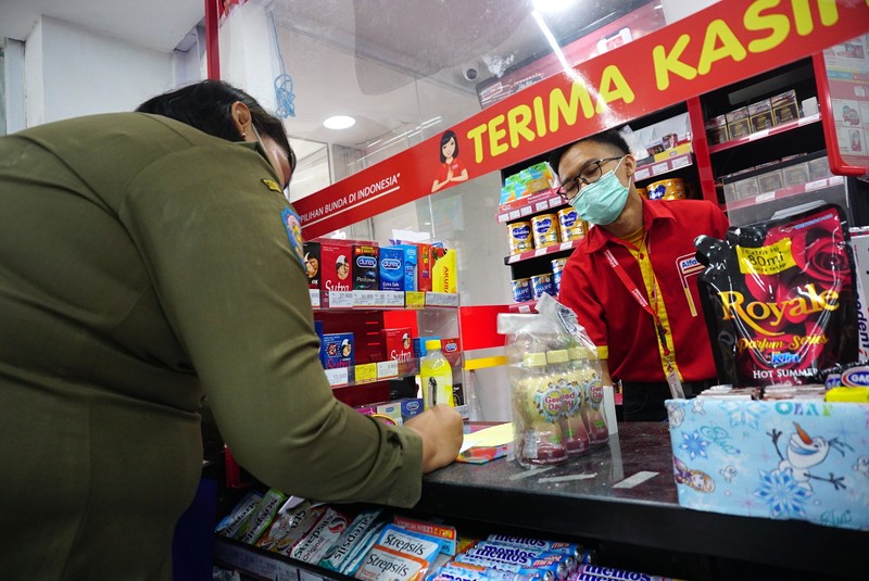 Petugas Satpol PP Jakarta Barat menutup gerai minimarket yang menjual rokok di Alfamart, Jakarta Barat, Selasa (14/9/2021). (CNBC Indonesia/Tri Susilo)
