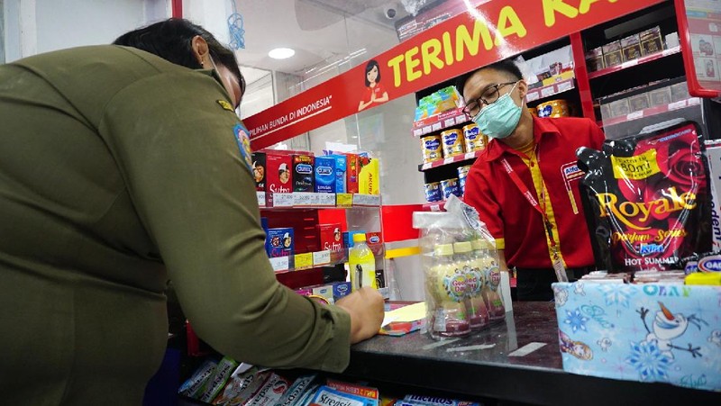 Petugas Satpol PP Jakarta Barat menutup gerai minimarket yang menjual rokok di Alfamart, Jakarta Barat, Selasa (14/9/2021). (CNBC Indonesia/Tri Susilo)