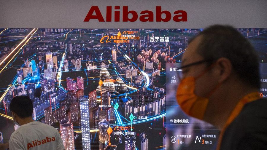 Visitors and staff members walk past an electronic display at a booth for Chinese technology firm Alibaba at the China International Fair for Trade in Services (CIFTIS) in Beijing, Friday, Sept. 3, 2021. E-commerce giant Alibaba Group said Friday it will spend $15.5 billion to support President Xi Jinping's campaign to spread China's prosperity more evenly, adding to pledges by tech companies that are under pressure to pay for the ruling Communist Party's political initiatives. (AP Photo/Mark Schiefelbein)