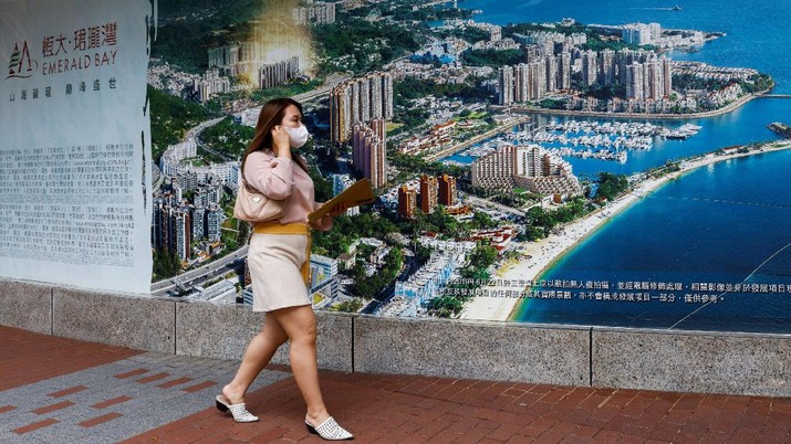 CHINA-EVERGRANDE/ A woman walks past a property advertisement for Emerald Bay by China Evergrande in Hong Kong, China. August 25, 2021. REUTERS/Tyrone Siu