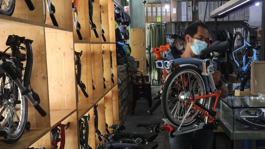 Pekerja memeriksa sepeda lipat brompton yang dijual di SpinWarriors, Tangerang Selatan, Kamis (15/9/2021). (CNBC Indonesia/Andrean Kristianto))