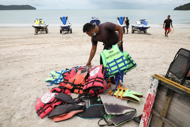 HEALTH-CORONAVIRUS/MALAYSIA-TOURISM A Malaysia Airlines crew member directs the first batch of tourists upon their arrival at the airport as Langkawi reopen to domestic tourists, amid the coronavirus disease (COVID-19) pandemic in Malaysia September 16, 2021. REUTERS/Lim Huey Teng