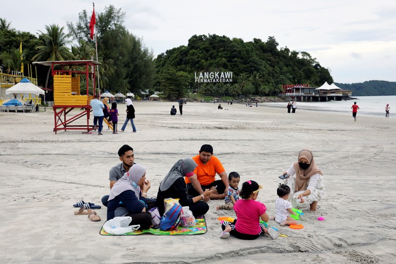 A Malaysia Airlines crew member directs the first batch of tourists upon their arrival at the airport as Langkawi reopen to domestic tourists, amid the coronavirus disease (COVID-19) pandemic in Malaysia September 16, 2021. REUTERS/Lim Huey Teng