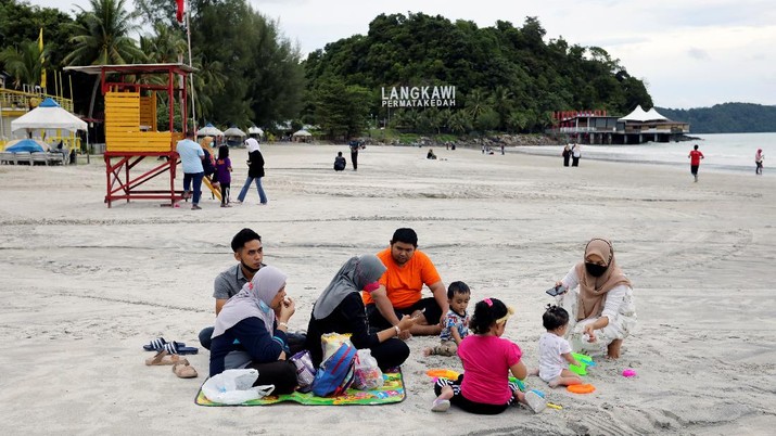People have a picnic at the Cenang Beach as Langkawi gets ready to open to domestic tourists from September 16, amid the coronavirus disease (COVID-19) outbreak, Malaysia September 14, 2021. REUTERS/Lim Huey Teng