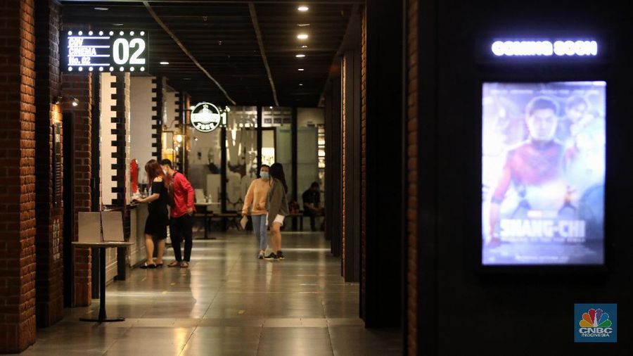 Pengunjung membeli tiket saat akan menonton bioskop di CGV Central Park, Jakarta, Kamis (16/9/2021). Pemerintah telah mengumumkan bioskop boleh kembali beroperasi untuk wilayah yang berada di level 2-3 PPKM di wilayah Jawa-Bali maupun luar Jawa-Bali. Pemprov DKI Jakarta hari ini melakukan uji coba pembukaan bioskop selama penerapan pemberlakuan pembatasan kegiatan masyarakat (PPKM) level 3. Uji coba dilakukan di seluruh bioskop di Jakarta. Pembukaan bisokop tersebut harus menerapkan protokol kesehatan yang ketat. Pengunjung yang datang harus menyiapkan aplikasi dan akun PeduliLindungi. Saat akan masuk, ada ketentuan scan QR Code di pintu masuk Platinum, kemudian klik check-in. Begitu pun saat keluar pengunjung harus meng-klik check-out di aplikasi. Selain menggunakan aplikasi PeduliLindung pengunjung yang datang wajib sudah vaksin dua kali, berusia 12 tahun keatas serta maksimal kapasitas 50% tanpa makan dan minum di dalam ruangan. Aturan ini sesuai dengan Keputusan Gubernur (Kepgub) Nomor 1096 Tahun 2021 tentang PPKM Level 3. Kepgub tersebut ditandatangani Gubernur Anies Baswedan pada 13 September 2021. Di bisokop yang berlokasi di Central Park ini, menayangkan beragam film favorit seperti Black Widow, Shang-Chi, Malignant, The Suicide Squad, Free Guy, Snake Eyes, Space jam, Stillwater, Hard Hit, Escape From Mogadishu, Blackpink : The Movie. Dari pantau di lokasi, pengunjung yang datang untuk menonton masih sepi. Pasa sore hari ini pengunjung yang menonton di dalam studio tidak lebih dari 10 orang. Sebelumnya pada tanggal 5 Juli 2021, bioskop sempat berhenti beroperasi menyesuaikan regulasi PPKM guna menekan jumlah penyebaran Covid-19 yang semakin meluas. (CNBC Indonesia/Andrean Kristianto)