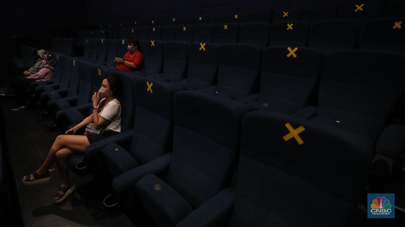 Pengunjung membeli tiket saat akan menonton bioskop di CGV Central Park, Jakarta, Kamis (16/9/2021). Pemerintah telah mengumumkan bioskop boleh kembali beroperasi untuk wilayah yang berada di level 2-3 PPKM di wilayah Jawa-Bali maupun luar Jawa-Bali. Pemprov DKI Jakarta hari ini melakukan uji coba pembukaan bioskop selama penerapan pemberlakuan pembatasan kegiatan masyarakat (PPKM) level 3. Uji coba dilakukan di seluruh bioskop di Jakarta. Pembukaan bisokop tersebut harus menerapkan protokol kesehatan yang ketat. Pengunjung yang datang harus menyiapkan aplikasi dan akun PeduliLindungi. Saat akan masuk, ada ketentuan scan QR Code di pintu masuk Platinum, kemudian klik check-in. Begitu pun saat keluar pengunjung harus meng-klik check-out di aplikasi. Selain menggunakan aplikasi PeduliLindung pengunjung yang datang wajib sudah vaksin dua kali, berusia 12 tahun keatas serta maksimal kapasitas 50% tanpa makan dan minum di dalam ruangan. Aturan ini sesuai dengan Keputusan Gubernur (Kepgub) Nomor 1096 Tahun 2021 tentang PPKM Level 3. Kepgub tersebut ditandatangani Gubernur Anies Baswedan pada 13 September 2021. Di bisokop yang berlokasi di Central Park ini, menayangkan beragam film favorit seperti Black Widow, Shang-Chi, Malignant, The Suicide Squad, Free Guy, Snake Eyes, Space jam, Stillwater, Hard Hit, Escape From Mogadishu, Blackpink : The Movie. Dari pantau di lokasi, pengunjung yang datang untuk menonton masih sepi. Pasa sore hari ini pengunjung yang menonton di dalam studio tidak lebih dari 10 orang. Sebelumnya pada tanggal 5 Juli 2021, bioskop sempat berhenti beroperasi menyesuaikan regulasi PPKM guna menekan jumlah penyebaran Covid-19 yang semakin meluas. (CNBC Indonesia/Andrean Kristianto)