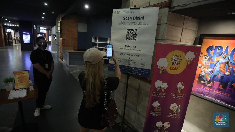 Pengunjung membeli tiket saat akan menonton bioskop di CGV Central Park, Jakarta, Kamis (16/9/2021). Pemerintah telah mengumumkan bioskop boleh kembali beroperasi untuk wilayah yang berada di level 2-3 PPKM di wilayah Jawa-Bali maupun luar Jawa-Bali. Pemprov DKI Jakarta hari ini melakukan uji coba pembukaan bioskop selama penerapan pemberlakuan pembatasan kegiatan masyarakat (PPKM) level 3. Uji coba dilakukan di seluruh bioskop di Jakarta. Pembukaan bisokop tersebut harus menerapkan protokol kesehatan yang ketat. Pengunjung yang datang harus menyiapkan aplikasi dan akun PeduliLindungi. Saat akan masuk, ada ketentuan scan QR Code di pintu masuk Platinum, kemudian klik check-in. Begitu pun saat keluar pengunjung harus meng-klik check-out di aplikasi. Selain menggunakan aplikasi PeduliLindung pengunjung yang datang wajib sudah vaksin dua kali, berusia 12 tahun keatas serta maksimal kapasitas 50% tanpa makan dan minum di dalam ruangan. Aturan ini sesuai dengan Keputusan Gubernur (Kepgub) Nomor 1096 Tahun 2021 tentang PPKM Level 3. Kepgub tersebut ditandatangani Gubernur Anies Baswedan pada 13 September 2021. Di bisokop yang berlokasi di Central Park ini, menayangkan beragam film favorit seperti Black Widow, Shang-Chi, Malignant, The Suicide Squad, Free Guy, Snake Eyes, Space jam, Stillwater, Hard Hit, Escape From Mogadishu, Blackpink : The Movie. Dari pantau di lokasi, pengunjung yang datang untuk menonton masih sepi. Pasa sore hari ini pengunjung yang menonton di dalam studio tidak lebih dari 10 orang. Sebelumnya pada tanggal 5 Juli 2021, bioskop sempat berhenti beroperasi menyesuaikan regulasi PPKM guna menekan jumlah penyebaran Covid-19 yang semakin meluas. (CNBC Indonesia/Andrean Kristianto)