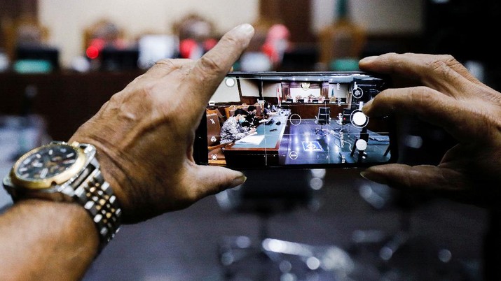 INDONESIA-POLLUTION/ A man takes pictures on a smartphone during the hearing of a citizen lawsuit, done in an attempt to sue the government into taking action on the city's chronic levels of air pollution, at the Central Jakarta Court, Indonesia, September 16, 2021. REUTERS/Willy Kurniawan REFILE - QUALITY REPEAT