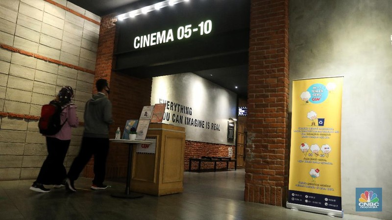 Pengunjung membeli tiket saat akan menonton bioskop di CGV Central Park, Jakarta, Kamis (16/9/2021). Pemerintah telah mengumumkan bioskop boleh kembali beroperasi untuk wilayah yang berada di level 2-3 PPKM di wilayah Jawa-Bali maupun luar Jawa-Bali. Pemprov DKI Jakarta hari ini melakukan uji coba pembukaan bioskop selama penerapan pemberlakuan pembatasan kegiatan masyarakat (PPKM) level 3. Uji coba dilakukan di seluruh bioskop di Jakarta. Pembukaan bisokop tersebut harus menerapkan protokol kesehatan yang ketat. Pengunjung yang datang harus menyiapkan aplikasi dan akun PeduliLindungi. Saat akan masuk, ada ketentuan scan QR Code di pintu masuk Platinum, kemudian klik check-in. Begitu pun saat keluar pengunjung harus meng-klik check-out di aplikasi. Selain menggunakan aplikasi PeduliLindung pengunjung yang datang wajib sudah vaksin dua kali, berusia 12 tahun keatas serta maksimal kapasitas 50% tanpa makan dan minum di dalam ruangan. Aturan ini sesuai dengan Keputusan Gubernur (Kepgub) Nomor 1096 Tahun 2021 tentang PPKM Level 3. Kepgub tersebut ditandatangani Gubernur Anies Baswedan pada 13 September 2021. Di bisokop yang berlokasi di Central Park ini, menayangkan beragam film favorit seperti Black Widow, Shang-Chi, Malignant, The Suicide Squad, Free Guy, Snake Eyes, Space jam, Stillwater, Hard Hit, Escape From Mogadishu, Blackpink : The Movie. Dari pantau di lokasi, pengunjung yang datang untuk menonton masih sepi. Pasa sore hari ini pengunjung yang menonton di dalam studio tidak lebih dari 10 orang. Sebelumnya pada tanggal 5 Juli 2021, bioskop sempat berhenti beroperasi menyesuaikan regulasi PPKM guna menekan jumlah penyebaran Covid-19 yang semakin meluas. (CNBC Indonesia/Andrean Kristianto)