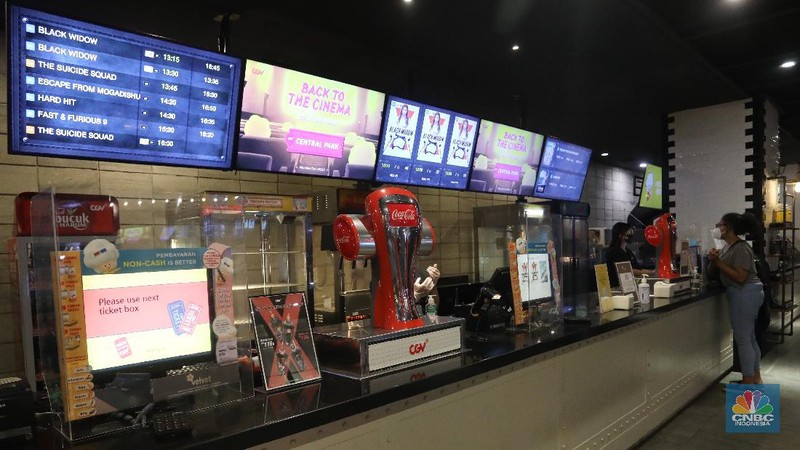 Pengunjung membeli tiket saat akan menonton bioskop di CGV Central Park, Jakarta, Kamis (16/9/2021). Pemerintah telah mengumumkan bioskop boleh kembali beroperasi untuk wilayah yang berada di level 2-3 PPKM di wilayah Jawa-Bali maupun luar Jawa-Bali. Pemprov DKI Jakarta hari ini melakukan uji coba pembukaan bioskop selama penerapan pemberlakuan pembatasan kegiatan masyarakat (PPKM) level 3. Uji coba dilakukan di seluruh bioskop di Jakarta. Pembukaan bisokop tersebut harus menerapkan protokol kesehatan yang ketat. Pengunjung yang datang harus menyiapkan aplikasi dan akun PeduliLindungi. Saat akan masuk, ada ketentuan scan QR Code di pintu masuk Platinum, kemudian klik check-in. Begitu pun saat keluar pengunjung harus meng-klik check-out di aplikasi. Selain menggunakan aplikasi PeduliLindung pengunjung yang datang wajib sudah vaksin dua kali, berusia 12 tahun keatas serta maksimal kapasitas 50% tanpa makan dan minum di dalam ruangan. Aturan ini sesuai dengan Keputusan Gubernur (Kepgub) Nomor 1096 Tahun 2021 tentang PPKM Level 3. Kepgub tersebut ditandatangani Gubernur Anies Baswedan pada 13 September 2021. Di bisokop yang berlokasi di Central Park ini, menayangkan beragam film favorit seperti Black Widow, Shang-Chi, Malignant, The Suicide Squad, Free Guy, Snake Eyes, Space jam, Stillwater, Hard Hit, Escape From Mogadishu, Blackpink : The Movie. Dari pantau di lokasi, pengunjung yang datang untuk menonton masih sepi. Pasa sore hari ini pengunjung yang menonton di dalam studio tidak lebih dari 10 orang. Sebelumnya pada tanggal 5 Juli 2021, bioskop sempat berhenti beroperasi menyesuaikan regulasi PPKM guna menekan jumlah penyebaran Covid-19 yang semakin meluas. (CNBC Indonesia/Andrean Kristianto)