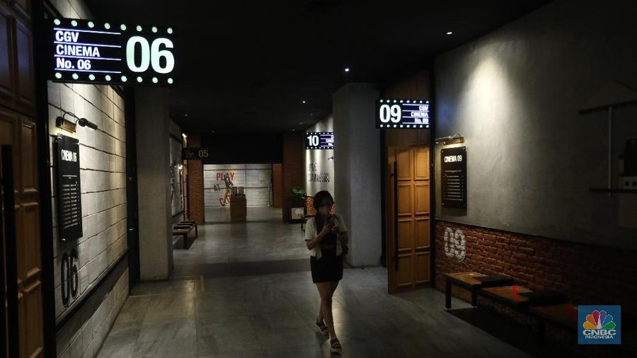 Pengunjung membeli tiket saat akan menonton bioskop di CGV Central Park, Jakarta, Kamis (16/9/2021). Pemerintah telah mengumumkan bioskop boleh kembali beroperasi untuk wilayah yang berada di level 2-3 PPKM di wilayah Jawa-Bali maupun luar Jawa-Bali. Pemprov DKI Jakarta hari ini melakukan uji coba pembukaan bioskop selama penerapan pemberlakuan pembatasan kegiatan masyarakat (PPKM) level 3. Uji coba dilakukan di seluruh bioskop di Jakarta. Pembukaan bisokop tersebut harus menerapkan protokol kesehatan yang ketat. Pengunjung yang datang harus menyiapkan aplikasi dan akun PeduliLindungi. Saat akan masuk, ada ketentuan scan QR Code di pintu masuk Platinum, kemudian klik check-in. Begitu pun saat keluar pengunjung harus meng-klik check-out di aplikasi. Selain menggunakan aplikasi PeduliLindung pengunjung yang datang wajib sudah vaksin dua kali, berusia 12 tahun keatas serta maksimal kapasitas 50% tanpa makan dan minum di dalam ruangan. Aturan ini sesuai dengan Keputusan Gubernur (Kepgub) Nomor 1096 Tahun 2021 tentang PPKM Level 3. Kepgub tersebut ditandatangani Gubernur Anies Baswedan pada 13 September 2021. Di bisokop yang berlokasi di Central Park ini, menayangkan beragam film favorit seperti Black Widow, Shang-Chi, Malignant, The Suicide Squad, Free Guy, Snake Eyes, Space jam, Stillwater, Hard Hit, Escape From Mogadishu, Blackpink : The Movie. Dari pantau di lokasi, pengunjung yang datang untuk menonton masih sepi. Pasa sore hari ini pengunjung yang menonton di dalam studio tidak lebih dari 10 orang. Sebelumnya pada tanggal 5 Juli 2021, bioskop sempat berhenti beroperasi menyesuaikan regulasi PPKM guna menekan jumlah penyebaran Covid-19 yang semakin meluas. (CNBC Indonesia/Andrean Kristianto)