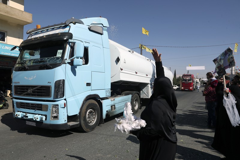 A convoy of tanker trucks carrying Iranian diesel crossing the border from Syria into Lebanon, arrive at the eastern town of el-Ain, Lebanon, Thursday, Sept. 16, 2021. The delivery, organized by the Iranian-backed Hezbollah group, violates U.S. sanctions imposed on Tehran after former President Donald Trump pulled America out of a nuclear deal between Iran and world powers three years ago. (AP Photo/Bilal Hussein)