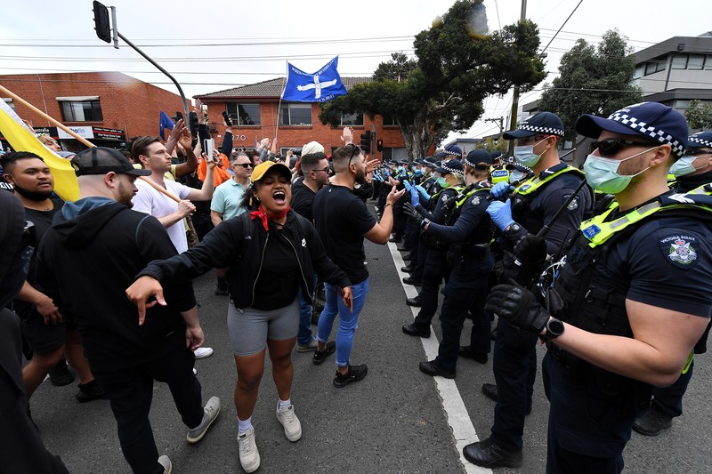 HEALTH-CORONAVIRUS/AUSTRALIA-PROTEST A protester is detained by Victoria police during a