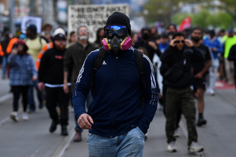 HEALTH-CORONAVIRUS/AUSTRALIA-PROTEST A protester is detained by Victoria police during a