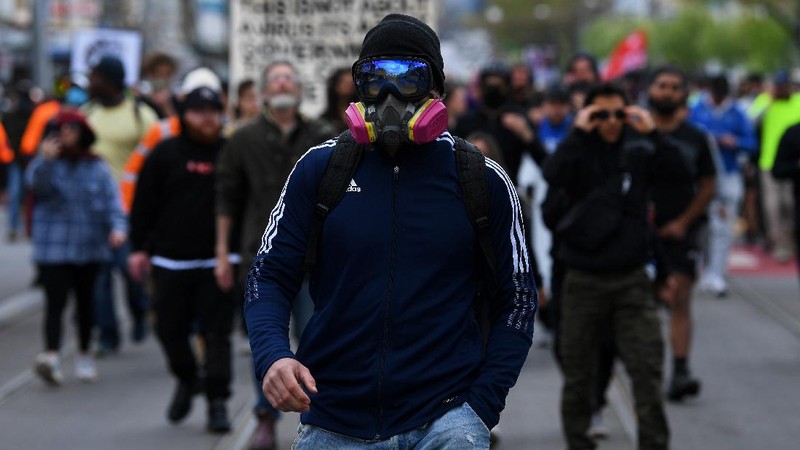 A protester is detained by Victoria police during a 