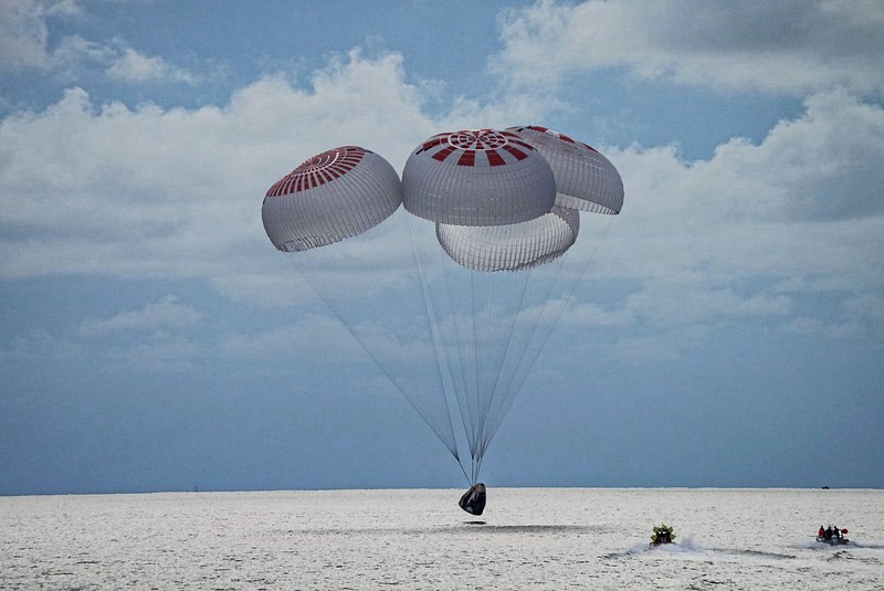 In this image taken from SpaceX video, passengers aboard a SpaceX capsule react as the capsule parachutes into the Atlantic Ocean off the Florida coast, Saturday, Sept. 18, 2021. The all-amateur crew was the first to circle the world without a professional astronaut.  (SpaceX via AP)