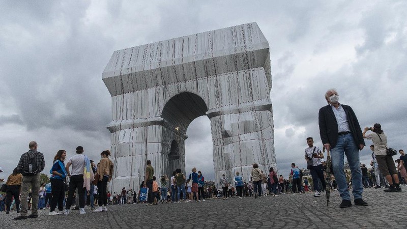 Mexican tourists pose for a selfie in front of the wrapped Arc de Triomphe monument Saturday, Sept. 18, 2021 in Paris. The 