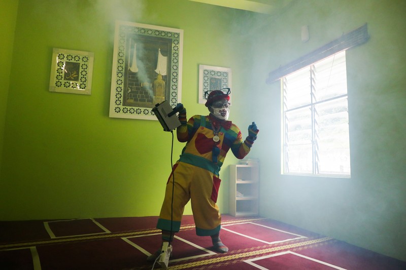 HEALTH-CORONAVIRUS/MALAYSIA-CLOWN Shaharul Hisam bin Baharuddin, 43, dressed as a clown, disinfects a prayer room inside a shopping mall in Taiping, Malaysia September 10, 2021. Picture taken September 10, 2021. REUTERS/Lim Huey Teng