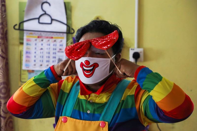 HEALTH-CORONAVIRUS/MALAYSIA-CLOWN Shaharul Hisam bin Baharuddin, 43, dressed as a clown, disinfects a prayer room inside a shopping mall in Taiping, Malaysia September 10, 2021. Picture taken September 10, 2021. REUTERS/Lim Huey Teng