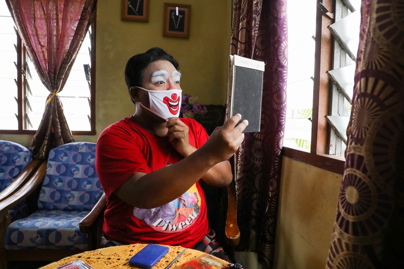 Shaharul Hisam bin Baharuddin, 43, dressed as a clown, disinfects a prayer room inside a shopping mall in Taiping, Malaysia September 10, 2021. Picture taken September 10, 2021. REUTERS/Lim Huey Teng