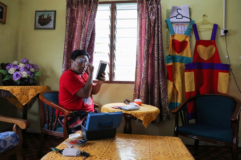 HEALTH-CORONAVIRUS/MALAYSIA-CLOWN Shaharul Hisam bin Baharuddin, 43, dressed as a clown, disinfects a prayer room inside a shopping mall in Taiping, Malaysia September 10, 2021. Picture taken September 10, 2021. REUTERS/Lim Huey Teng