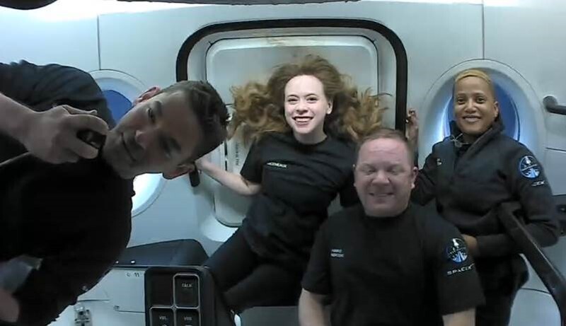 In this image taken from SpaceX video, passengers aboard a SpaceX capsule react as the capsule parachutes into the Atlantic Ocean off the Florida coast, Saturday, Sept. 18, 2021. The all-amateur crew was the first to circle the world without a professional astronaut.  (SpaceX via AP)