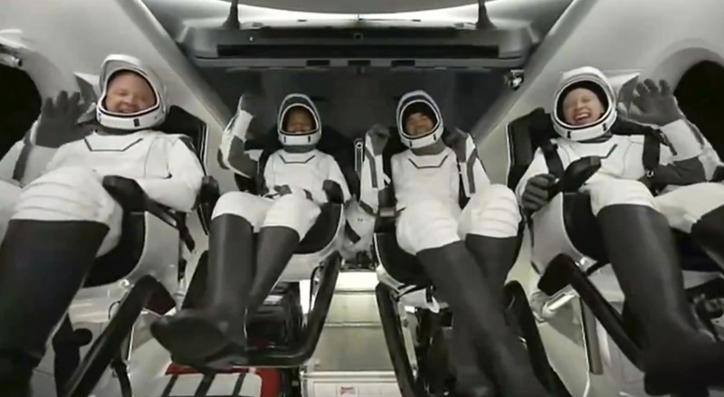 In this image taken from SpaceX video, passengers aboard a SpaceX capsule react as the capsule parachutes into the Atlantic Ocean off the Florida coast, Saturday, Sept. 18, 2021. The all-amateur crew was the first to circle the world without a professional astronaut.  (SpaceX via AP)