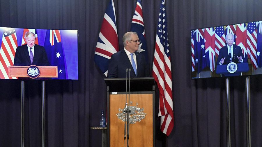 Australia's Prime Minister Scott Morrison, center, appears on stage with video links to Britain's Prime Minister Boris Johnson, left, and U.S. President Joe Biden at a joint press conference at Parliament House in Canberra, Thursday, Sept. 16, 2021. The leaders are announcing a security alliance that will allow for greater sharing of defense capabilities — including helping equip Australia with nuclear-powered submarines. (Mick Tsikas/AAP Image via AP)