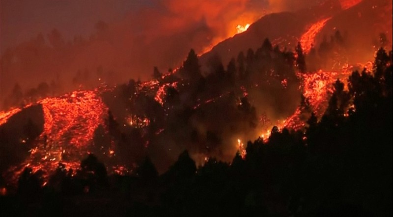 Residents watch lava following the eruption of a volcano in the Cumbre Vieja national park at El Paso, on the Canary Island of La Palma, September 19, 2021. Pictures taken September 19, 2021. REUTERS/Borja Suarez