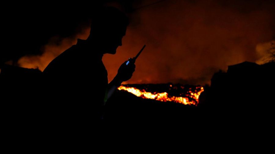 Residents watch lava following the eruption of a volcano in the Cumbre Vieja national park at El Paso, on the Canary Island of La Palma, September 19, 2021. Pictures taken September 19, 2021. REUTERS/Borja Suarez