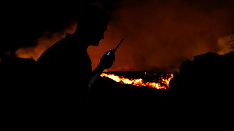 Residents watch lava following the eruption of a volcano in the Cumbre Vieja national park at El Paso, on the Canary Island of La Palma, September 19, 2021. Pictures taken September 19, 2021. REUTERS/Borja Suarez
