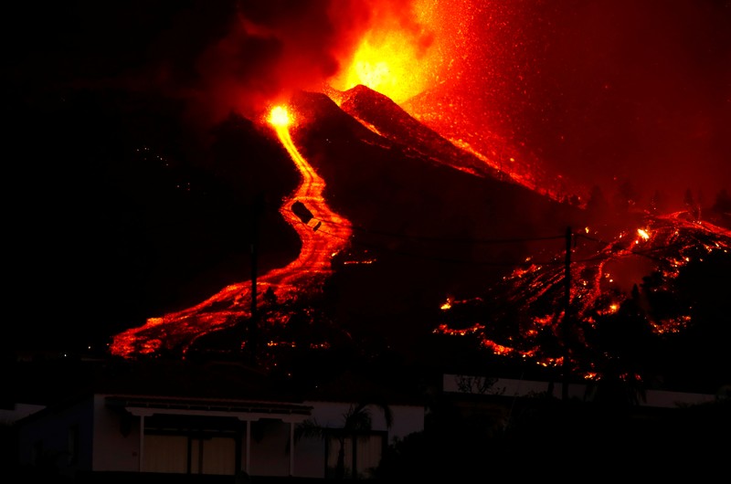 Residents watch lava following the eruption of a volcano in the Cumbre Vieja national park at El Paso, on the Canary Island of La Palma, September 19, 2021. Pictures taken September 19, 2021. REUTERS/Borja Suarez