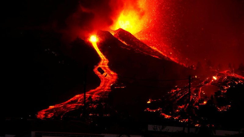Residents watch lava following the eruption of a volcano in the Cumbre Vieja national park at El Paso, on the Canary Island of La Palma, September 19, 2021. Pictures taken September 19, 2021. REUTERS/Borja Suarez