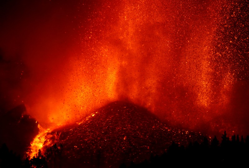 Residents watch lava following the eruption of a volcano in the Cumbre Vieja national park at El Paso, on the Canary Island of La Palma, September 19, 2021. Pictures taken September 19, 2021. REUTERS/Borja Suarez