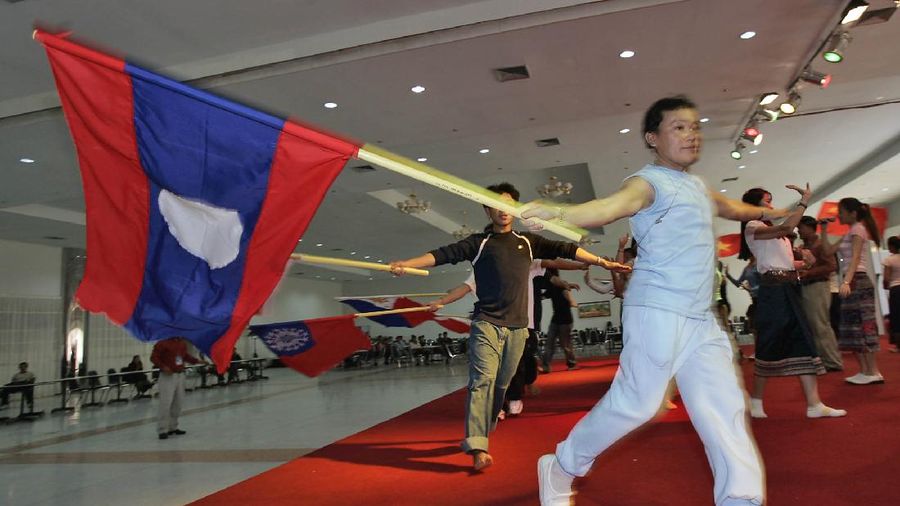 Performers wave flags during a practice session for  opening ceremonies of the 10th ASEAN summit in Vientiane, Laos, Wednesday, Nov. 24, 2004.  Laos, one of the poorest nations in Southeast Asia, is set to host the summit later this week.  Security for the event, the first ever to be held in Laos, is expected to be high as tourist visas are being denied during the summit meeting with streets and parks closed in the Lao Capital.  (AP Photo/David Longstreath)