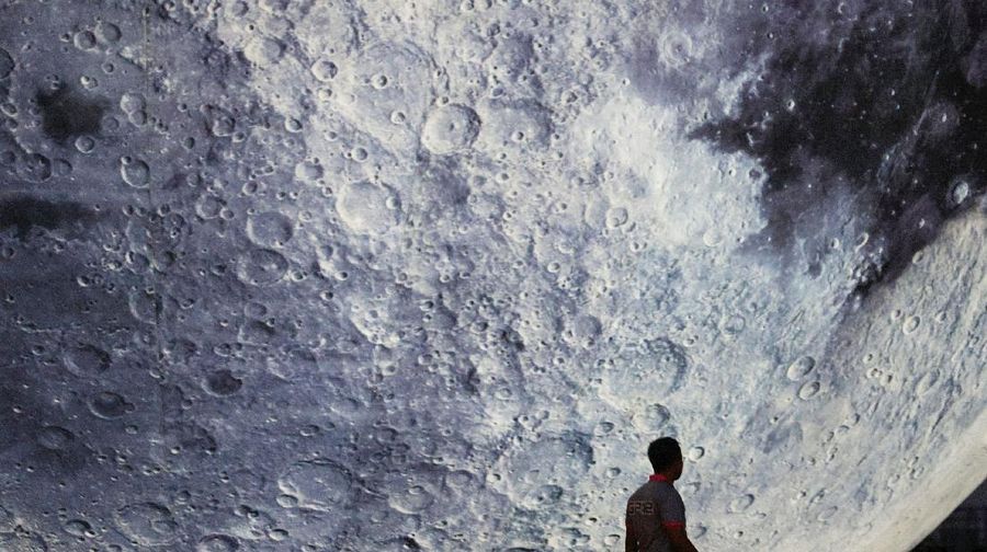A man walks in front of a giant moon-shaped balloon ahead of Mid-Autumn Festival, in Hong Kong, China September 20, 2021. REUTERS/Tyrone Siu