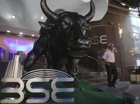 A man walks near the bronze statue of a bull outside the Bombay Stock Exchange (BSE) in Mumbai, India, Thursday, Oct. 4, 2018. Shares sank in India on concerns over continued weakness in the rupee and over the country's trade deficit thanks to surgin