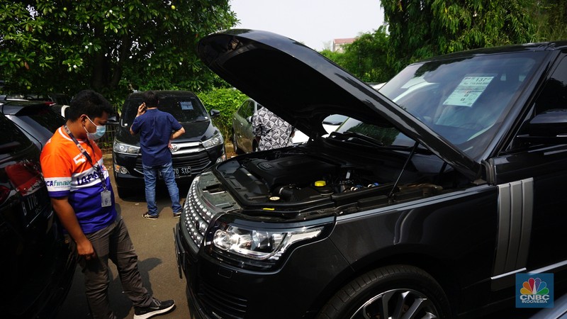 Calon pembeli memeriksa mobil lelangan yang berada di PT.JBA Indonesia, Jakarta, Selasa (21/9/2021). Dalam gelaran lelang yang diadakan oleh JBA Indonesia ini dilakukan secara terbuka untuk umum bahkan perorangan juga bisa mengikuti lelang mobil ini. Untuk mengikuti lelang ini cukup mudah, calon pembeli hanya perlu datang dalam melihat unit kendaraan, jika cocok bisa langsung daftar dengan mendepositkan sebesar Rp. 5 juta per satu unit kendaraan. Kegiatan lelang kendaraan ini hanya ada di setiap hari Selasa dibuka pada pukul 09:00-hingga selesai. Salah satu peserta lelang menjelaskan 