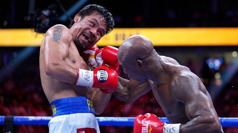 Aug 21, 2021; Las Vegas, Nevada; Manny Pacquiao (left) fights Yordenis Ugas in a world welterweight championship bout at T-Mobile Arena. Mandatory Credit: Stephen R. Sylvanie-USA TODAY Sports