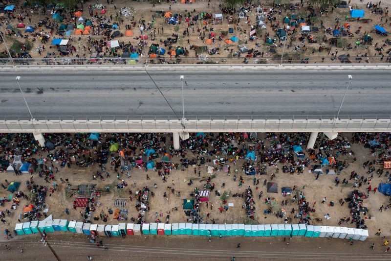 Migrants seeking refuge in the United States walk back into the Mexican side carrying their belongings inside plastic bags while crossing the Rio Bravo river which divides the border between Ciudad Acuna, Mexico and Del Rio, Texas, U.S., to avoid being deported, in Ciudad Acuna, Mexico, September 19, 2021. REUTERS/Daniel Becerril   REFILE- QUALITY REPEAT