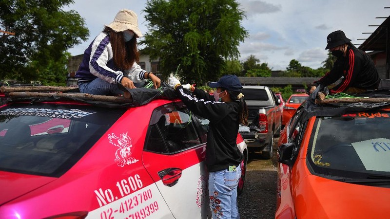 A worker plants vegetables on a roof of unused taxi due to the business crisis caused by the coronavirus disease (COVID-19) pandemic at a taxi garage in Bangkok, Thailand, September 16, 2021. Picture taken September 16, 2021. REUTERS/Chalinee Thirasupa