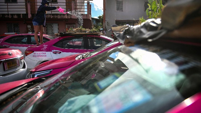 A worker plants vegetables on a roof of unused taxi due to the business crisis caused by the coronavirus disease (COVID-19) pandemic at a taxi garage in Bangkok, Thailand, September 16, 2021. Picture taken September 16, 2021. REUTERS/Chalinee Thirasupa