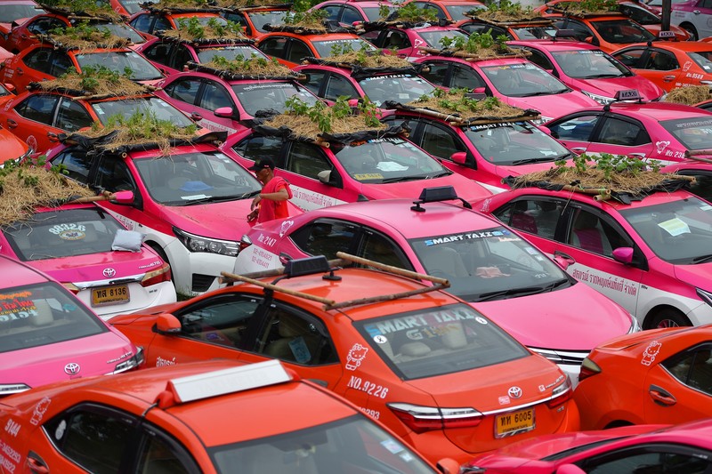 A worker plants vegetables on a roof of unused taxi due to the business crisis caused by the coronavirus disease (COVID-19) pandemic at a taxi garage in Bangkok, Thailand, September 16, 2021. Picture taken September 16, 2021. REUTERS/Chalinee Thirasupa