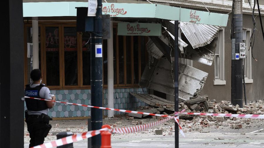 A person walks past damage to the exterior of a restaurant following an earthquake in the Windsor suburb of Melbourne, Australia, September 22, 2021.  AAP Image/James Ross via REUTERS  ATTENTION EDITORS - THIS IMAGE WAS PROVIDED BY A THIRD PARTY. NO RESALES. NO ARCHIVES. AUSTRALIA OUT. NEW ZEALAND OUT
