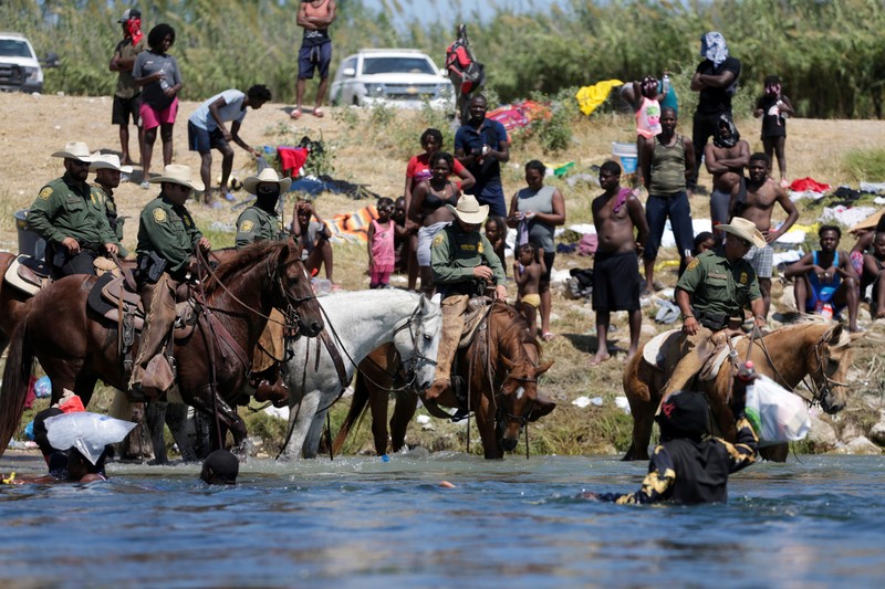 Patroli Perbatasan Amerika Serikat (AS) menggunakan kuda dalam operasi imigran ilegal Haiti U.S. Customs and Border Protection mounted officers attempt to contain migrants as they cross the Rio Grande from Ciudad Acuna, Mexico, into Del Rio, Texas, Sunday, Sept. 19, 2021. Criticism has been fueled by the images that went viral this week of Border Patrol agents on horseback using aggressive tactics against the migrants. (AP Photo/Felix Marquez)