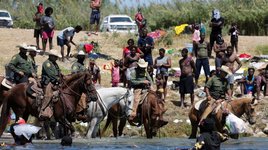 U.S. Customs and Border Protection mounted officers attempt to contain migrants as they cross the Rio Grande from Ciudad Acuna, Mexico, into Del Rio, Texas, Sunday, Sept. 19, 2021. Criticism has been fueled by the images that went viral this week of Border Patrol agents on horseback using aggressive tactics against the migrants. (AP Photo/Felix Marquez)