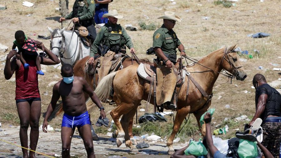 U.S. Customs and Border Protection mounted officers attempt to contain migrants as they cross the Rio Grande from Ciudad Acuna, Mexico, into Del Rio, Texas, Sunday, Sept. 19, 2021. Criticism has been fueled by the images that went viral this week of Border Patrol agents on horseback using aggressive tactics against the migrants. (AP Photo/Felix Marquez)
