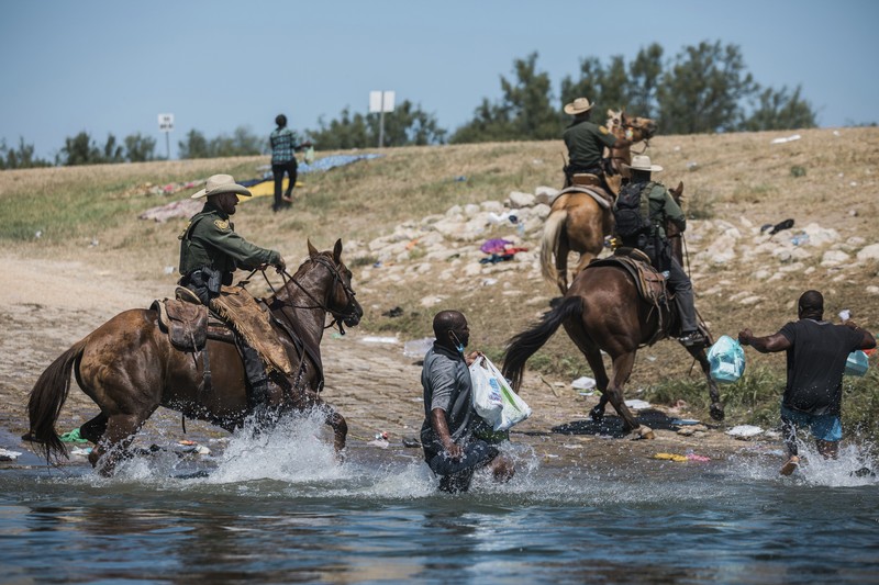 Patroli Perbatasan Amerika Serikat (AS) menggunakan kuda dalam operasi imigran ilegal Haiti U.S. Customs and Border Protection mounted officers attempt to contain migrants as they cross the Rio Grande from Ciudad Acuna, Mexico, into Del Rio, Texas, Sunday, Sept. 19, 2021. Criticism has been fueled by the images that went viral this week of Border Patrol agents on horseback using aggressive tactics against the migrants. (AP Photo/Felix Marquez)