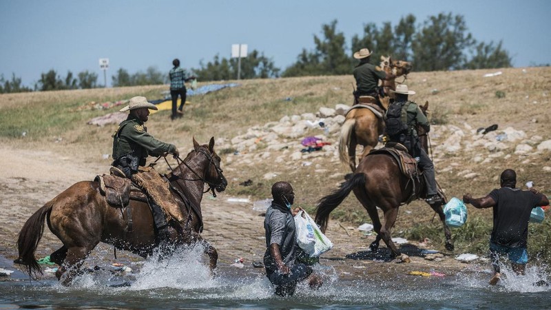 U.S. Customs and Border Protection mounted officers attempt to contain migrants as they cross the Rio Grande from Ciudad Acuna, Mexico, into Del Rio, Texas, Sunday, Sept. 19, 2021. Criticism has been fueled by the images that went viral this week of Border Patrol agents on horseback using aggressive tactics against the migrants. (AP Photo/Felix Marquez)